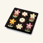 Chocolade Bloemen – Doosje 105g zijn verfijnde Belgische chocoladebonbons in de vorm van kleurrijke bloemen. Elke bonbon is gemaakt van rijke, romige chocolade die smelt in je mond en een heerlijke, zachte smaak vrijgeeft. De bloemen hebben een levendig ontwerp, met verschillende kleuren die de schoonheid en diversiteit van echte bloemen nabootsen. De verpakking bevat 105 gram van deze elegante lekkernijen, perfect verpakt in een stijlvolle doos. Deze chocoladebloemen zijn ideaal als een speciaal cadeau of om jezelf te verwennen met een luxe traktatie.